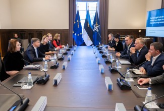 Inimesed ümber laua koosolekul. Taustal aken EL, Eesti ja Nato lippudega