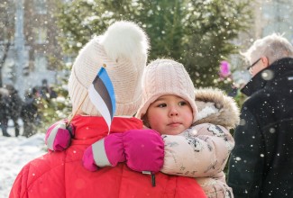 Laps ema süles, käes Eesti lipp. Foto: Aron Urb